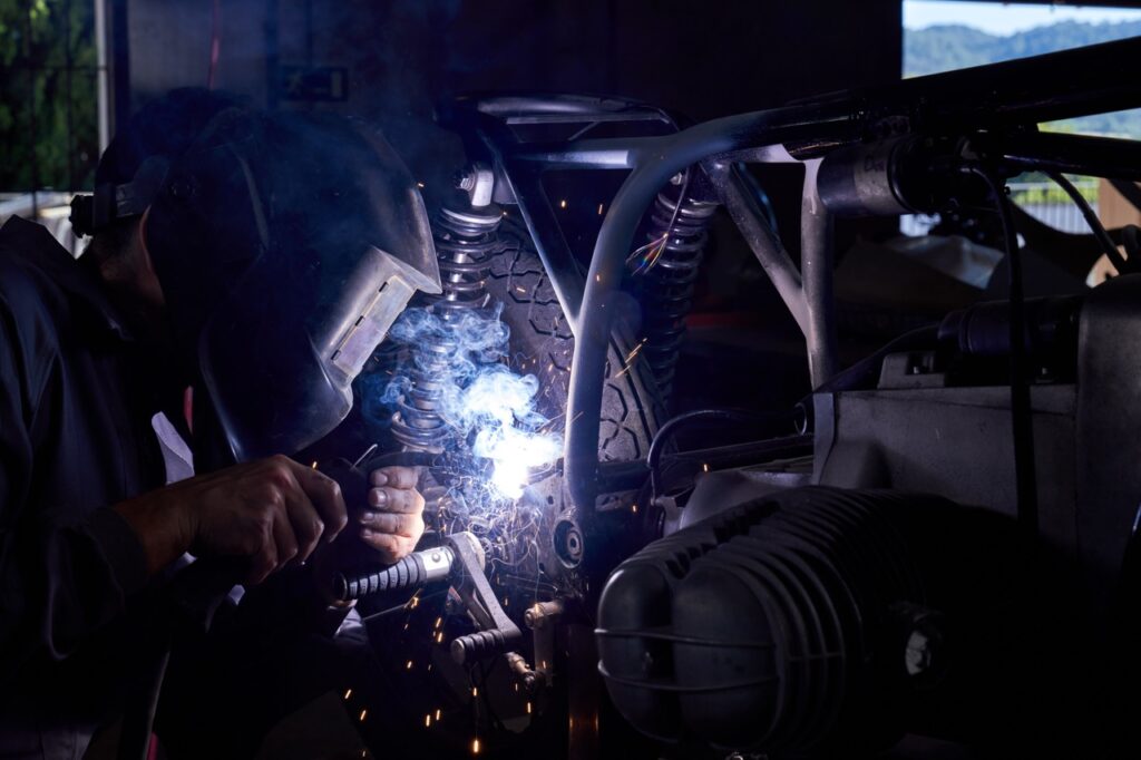A men working in professional workshop repairing a motorbike